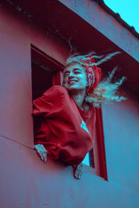 Low angle view of woman looking through window