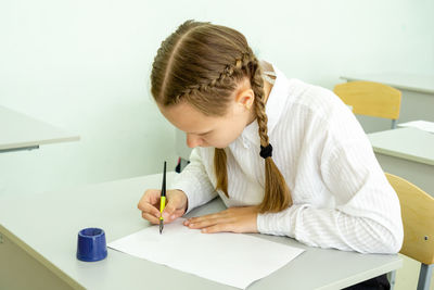 Girl drawing on paper at school