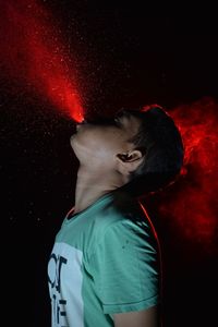 Portrait of young man against black background