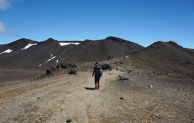 Full length rear view of man walking on mountain