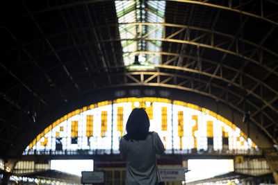 Rear view of woman standing in corridor