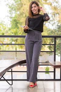 Full length of woman standing on mobile phone