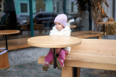 Portrait of girl sitting on table
