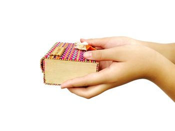 Close-up of woman holding hands over white background