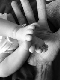 Close-up of father holding baby hand