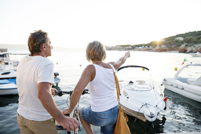 Back view of senior woman on a jetty looking at distance