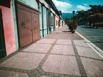 Footpath amidst buildings against sky in city