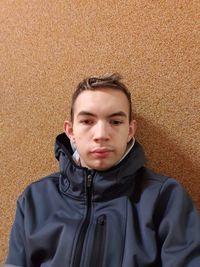 Portrait of young man against wall