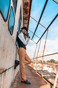 Man standing on bridge against sky