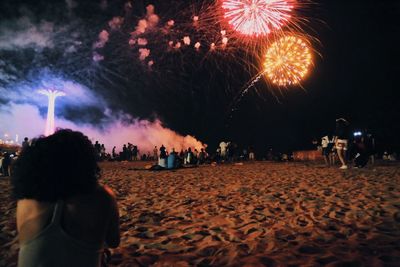 People at beach against sky at night