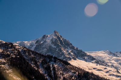 Scenic view of snowcapped mountains against clear blue sky