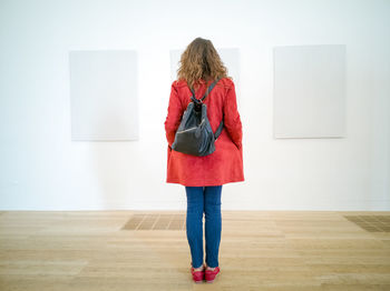 Rear view of woman standing against wall