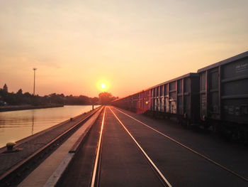 Railroad tracks against sky during sunset