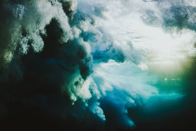 Low angle view of smoke in sea against sky