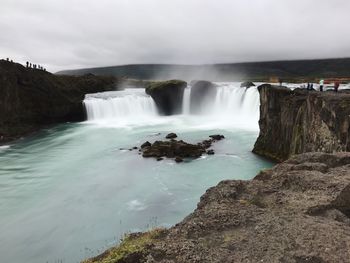 Scenic view of waterfall against sky