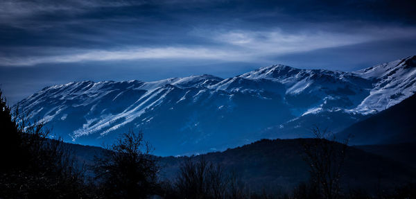 Scenic view of snowcapped mountain against cloudy sky