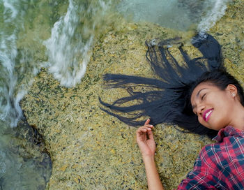 High angle portrait of smiling woman by sea