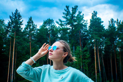 Portrait of boy holding plant in forest