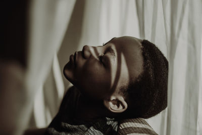 Close-up portrait of young woman with eyes closed at home