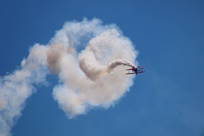 Low angle view of airshow against sky