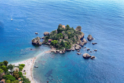 High angle view of island amidst sea against blue sky