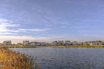 Scenic view of sea by buildings against sky