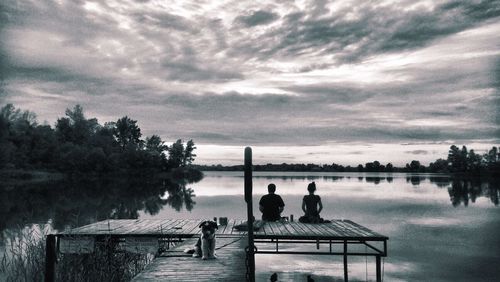 Pier on lake against cloudy sky