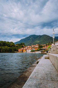 Scenic view of lake by buildings against sky in city