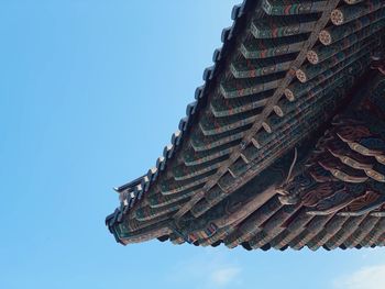 Low angle view of roof of building against clear blue sky