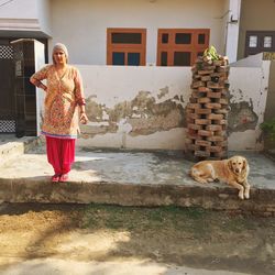 Full length of woman standing by building