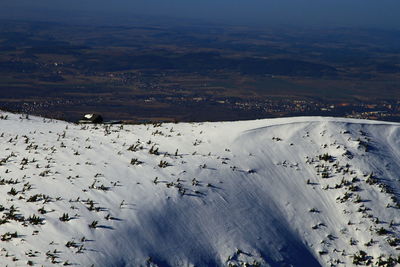 Aerial view of snow covered land against sky