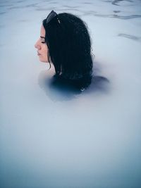 Young woman swimming in frozen lagoon