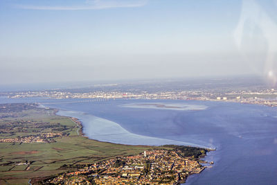 Aerial view of sea and cityscape against sky