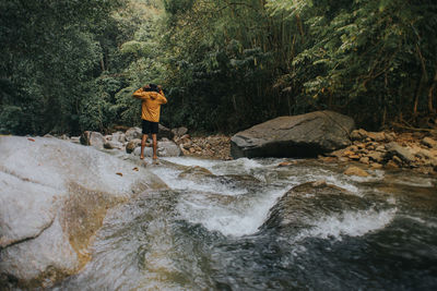 Male traveller explore the beautiful of rainforest stream in the morning.hiking and camping.