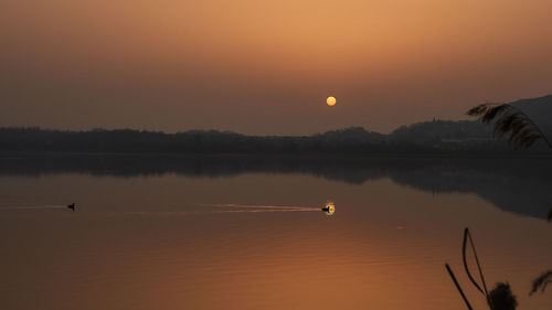 Scenic view of lake against sky during sunset