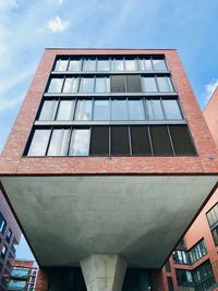 Low angle view of glass building against sky