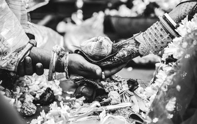 Cropped hands of bride and bridegroom holding religious offering during wedding ceremony