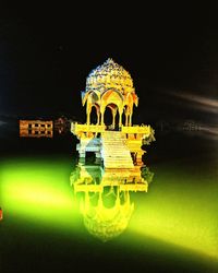 Illuminated building against sky at night