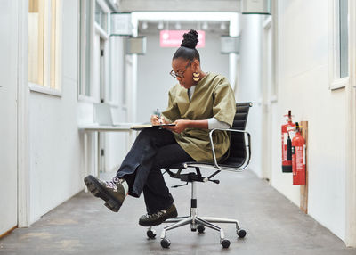 Cheerful smiling woman sitting on chair while sitting indoors