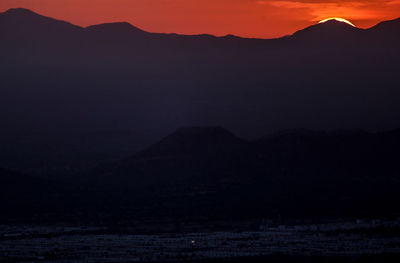 Scenic view of silhouette mountains against sky at sunset