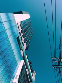 Low angle view of modern buildings against clear blue sky