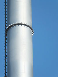 Low angle view of water tower against clear blue sky