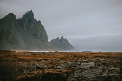 Scenic view of mountains by sea against sky