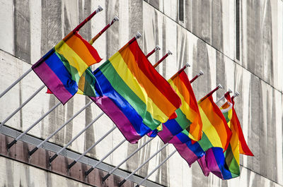 Ten rainbow flags on a stone facade