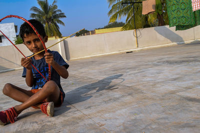 Full length of man sitting on palm tree