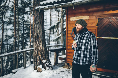 Man standing on snow covered tree during winter