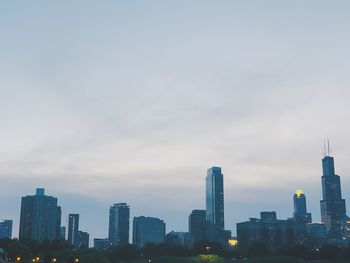 Buildings in city against cloudy sky