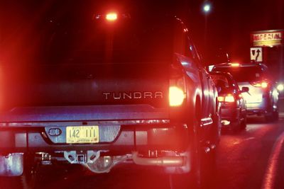 Close-up of illuminated text on street in city at night