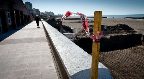 Man standing by building against sky