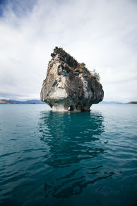 Rock formation in sea against sky